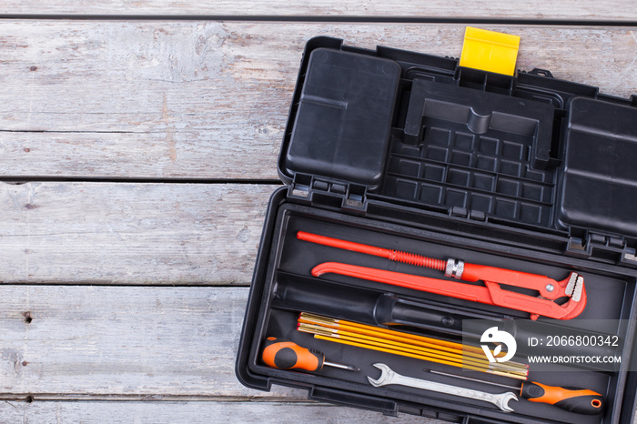 Black plastic tool box with construction instruments.