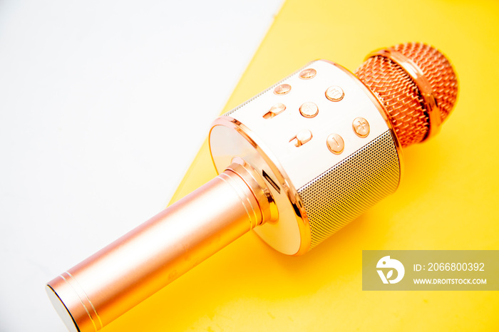 Pink-silver portable karaoke microphone for children on a bright yellow background