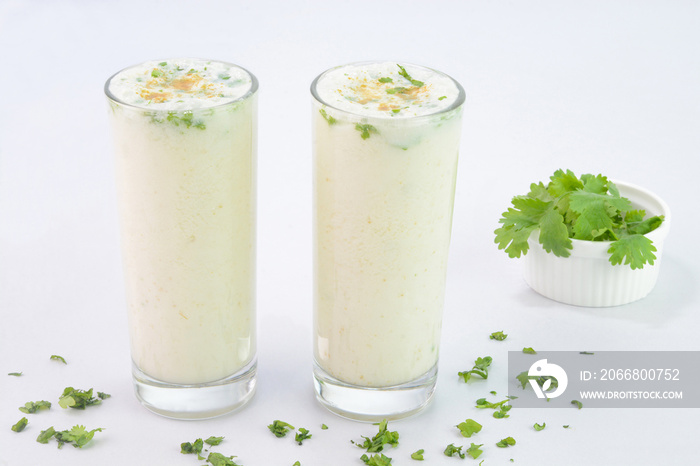 Buttermilk drink in glass cups on white background