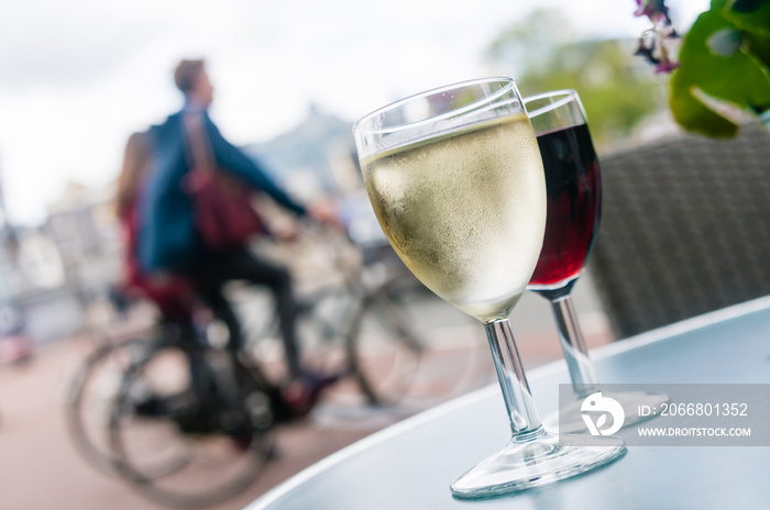 Glasses of white and red wine on a table outside a bar in Amsterdam