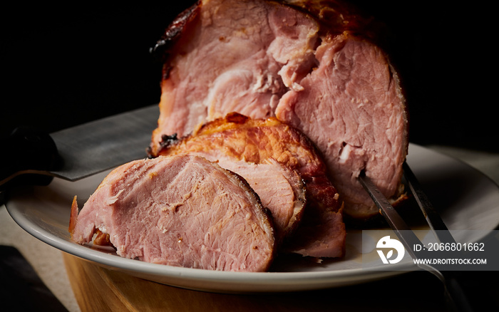 Honey and mustard roast gammon joint resting on serving plate.