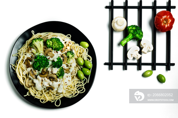 Traditional homemade italian pasta with chicken, mushrooms, broccoli, cream sauce, green olives and vegetables isolated on white background. Close-up. Top view. Flat lay composition.