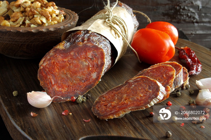 Croatian spicy sausage on wooden board. Kulen.