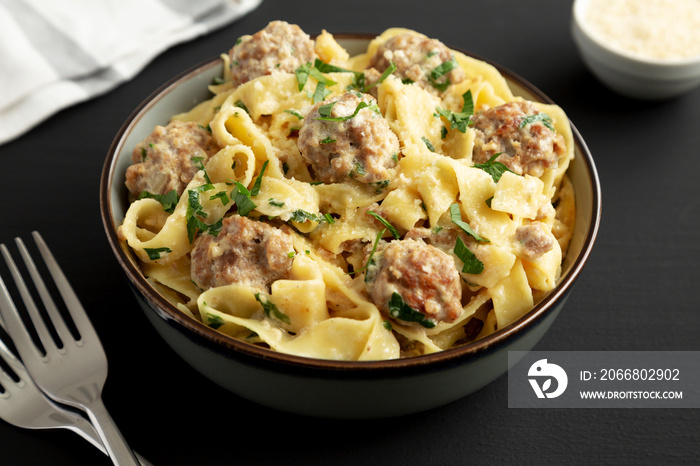 Homemade One-Pot Swedish Meatball Pasta in a Bowl on a black background, side view.