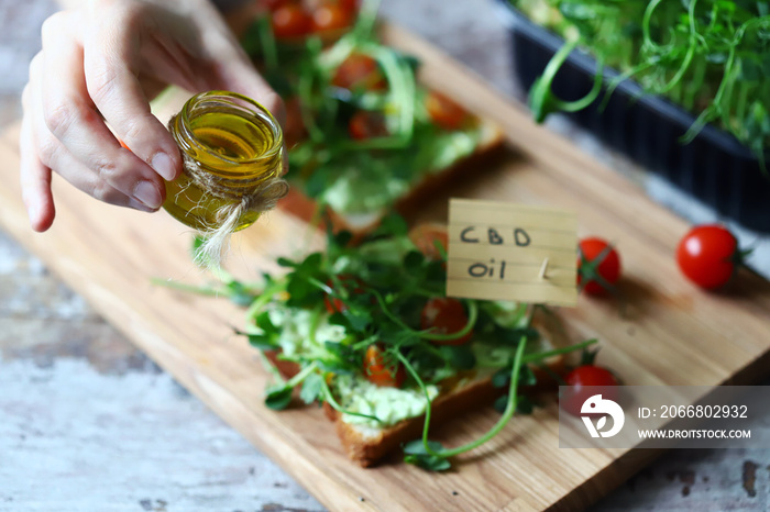Selective focus. Healthy toasts with microgreens and cbd oil. Cannabidiol concept. CBD oil. Cbd food.