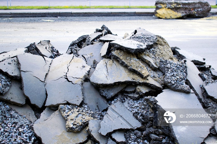 A pile of old asphalt, gravel and sand on the road.