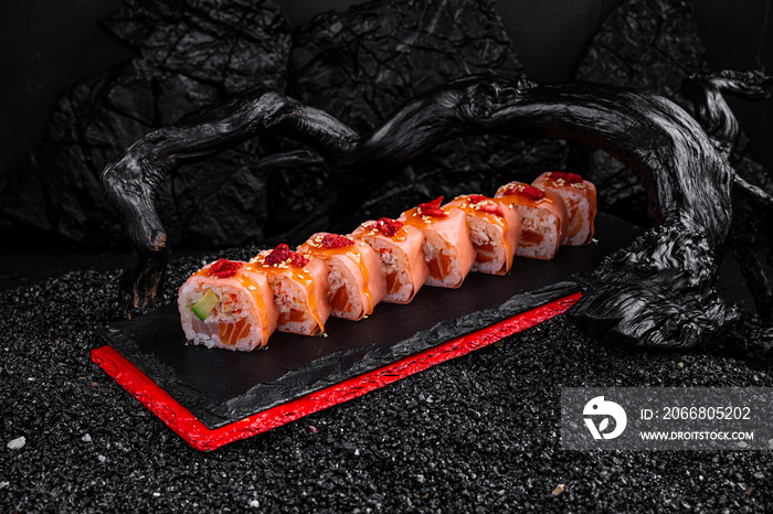 rolls with salmon tuna, avocado and shrimp on a black background
