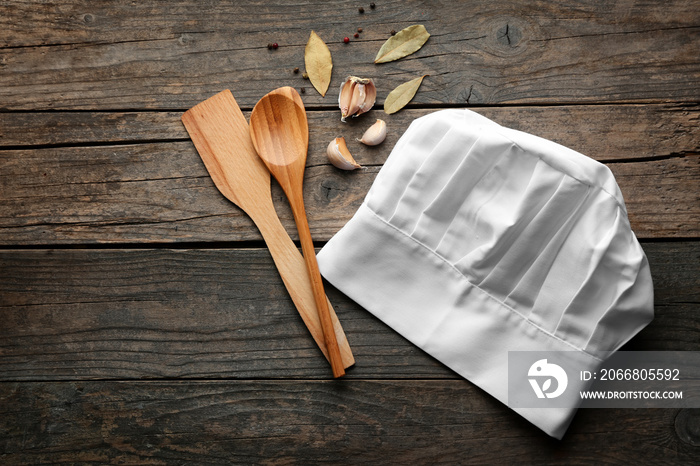 Chef’s hat, spoon and shovel on wooden table