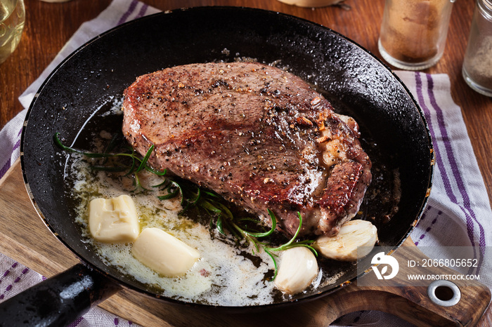 Preparing beef steak with cubed butter