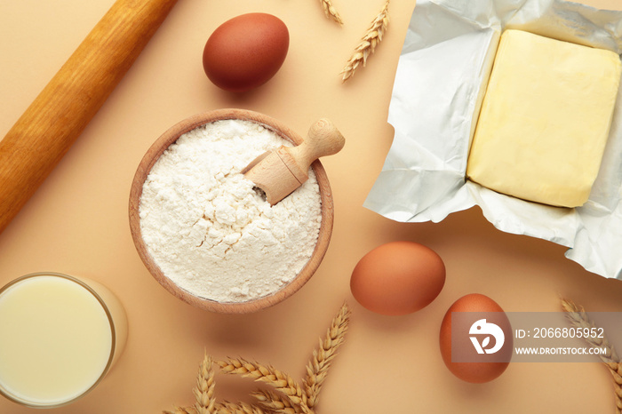 Ingredients for baking or cooking, egg flour, rolling pin butter, milk on a beige background Cookie pie or cake recipe.