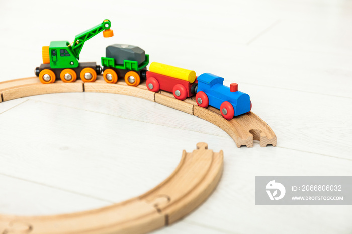 Child’d wooden train on the white floor