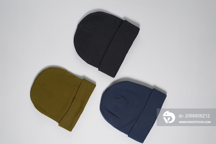 Flat lay template of khaki, dark blue and black hats, hipster beanie set isolated over gray background