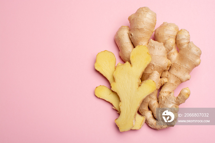 Trendy food flat lay concept on light pink background with fresh big ginger root close up copy space isolated