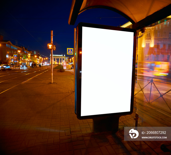 Billboard on the street Outdoor Advertising glows at night. Layout for advertising design. Sheet pylon with a white field in stopping pavilion bus shelter