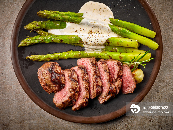 portion of sliced beef steak and asparagus