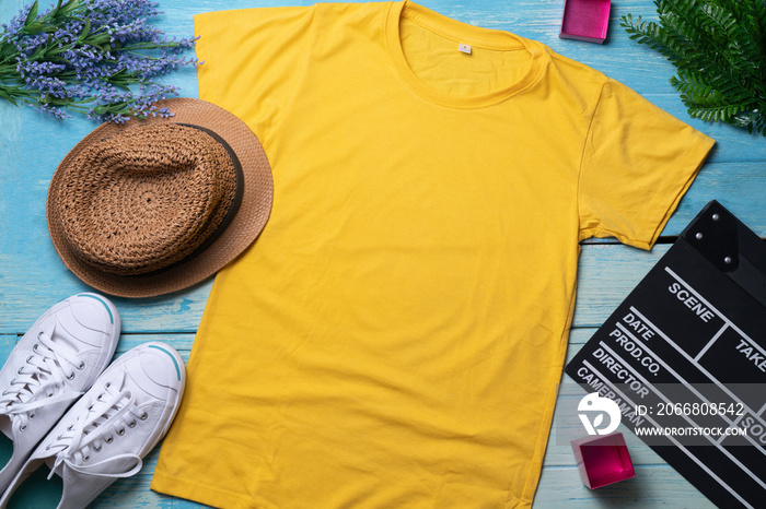 Mockup of a yellow t-shirt blank shirt template with accessories on the wooden blue table background, lifestyle and travel concept