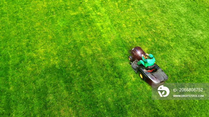 Lawnmower and gardener. Grass cutting in the garden.