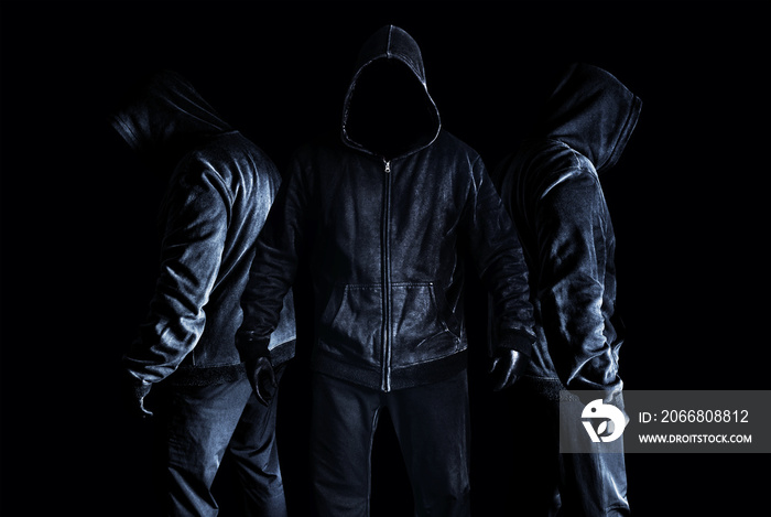 Photo of scary horror stranger stalker men in black hood and clothing on dark and misty background.