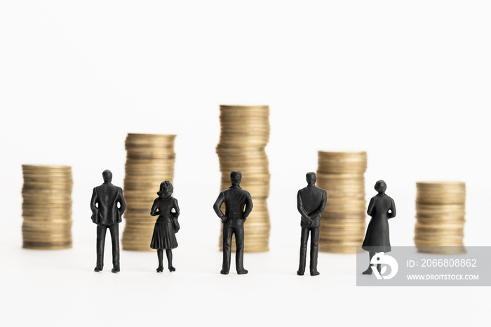 Group of figurines looking at stacks of coins