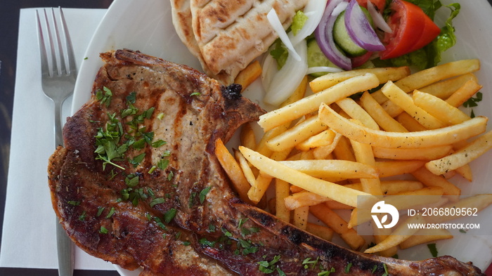 Grilled Giant Pork Chop with  chips and salad