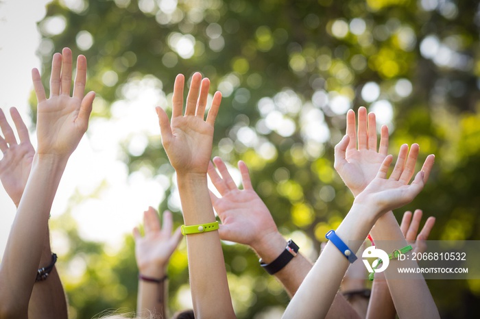 Friends raising their hands while dancing at music festival