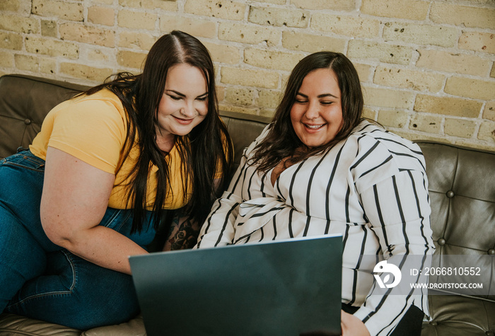 2 women look at laptop