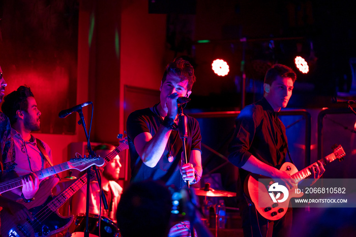 Musical group in concert, they play in a nightclub.