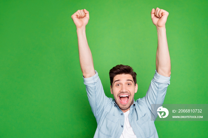 Photo of amazing crazy guy yelling loudly celebrating favorite football team victory raise fists up wear casual denim shirt isolated green color background