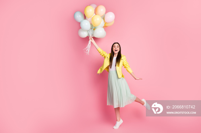 Full length body size view of nice attractive pretty fashionable glad cheerful cheery girl holding in hands air balls aving fun flying up isolated on bright vivid shine vibrant yellow color background