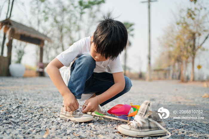 boy sitting in a park with shoelaces