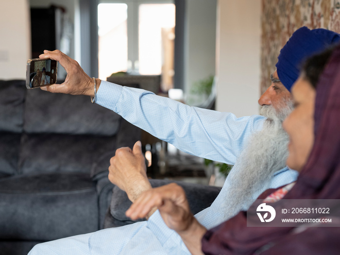 Senior couple in traditional clothing taking selfie