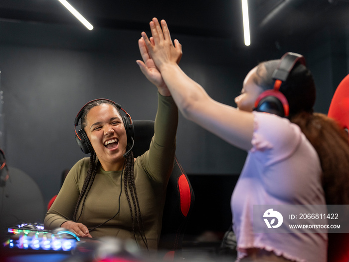 Female gamers giving high-five while playing video games