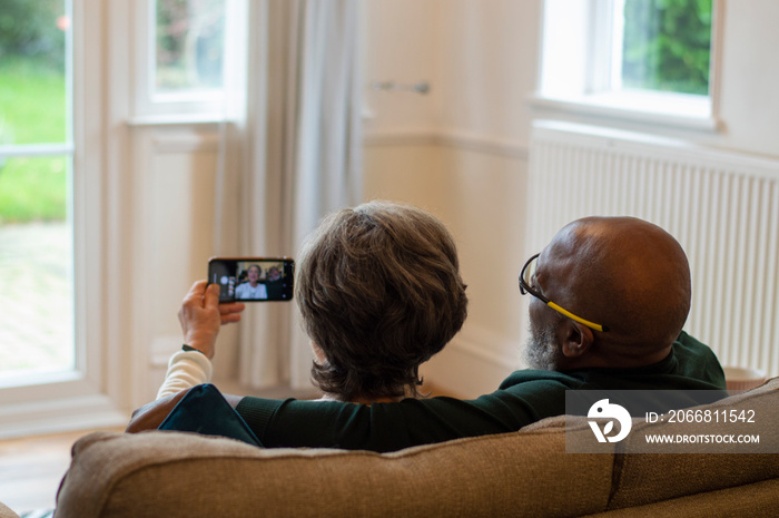 Senior couple using smart phone at home