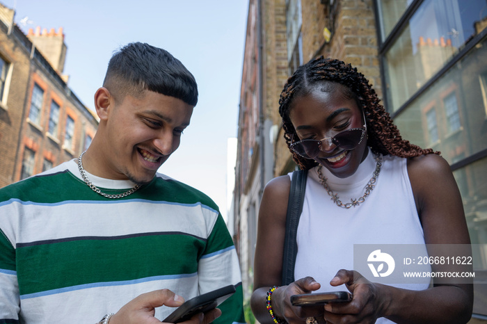 Smiling woman and man looking at smart phone together