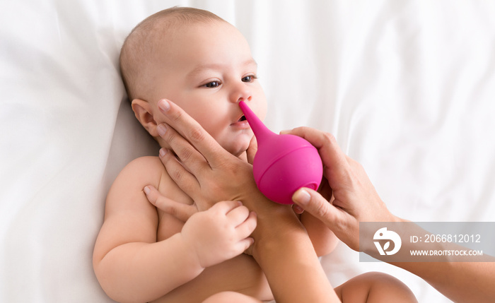 Newborn baby getting nose cleaning with cleaner