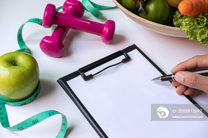 Clipboard with healthy fruit, vegetable and measuring tape on nutritionist desk, Right nutrition and diet concept