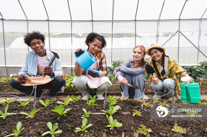 Teenagers holding farmer tool in organic greenhouse