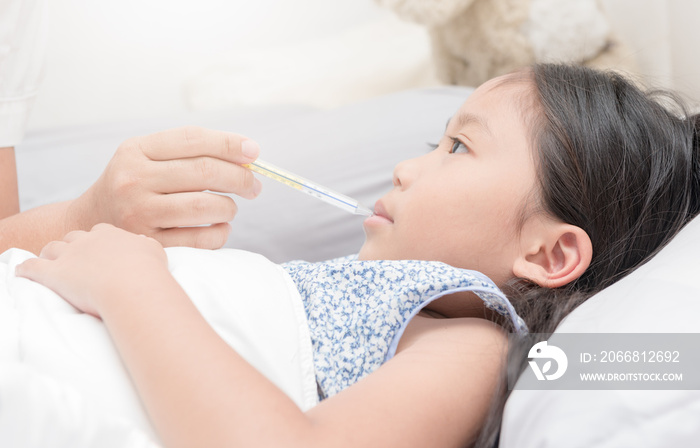 Mother measuring temperature of her ill kid