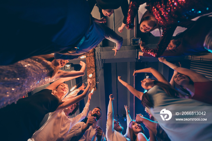 Low angle photo of cheerful positive crowd people students celebrate festive events stand round circle dance have fun raise hands on discotheque