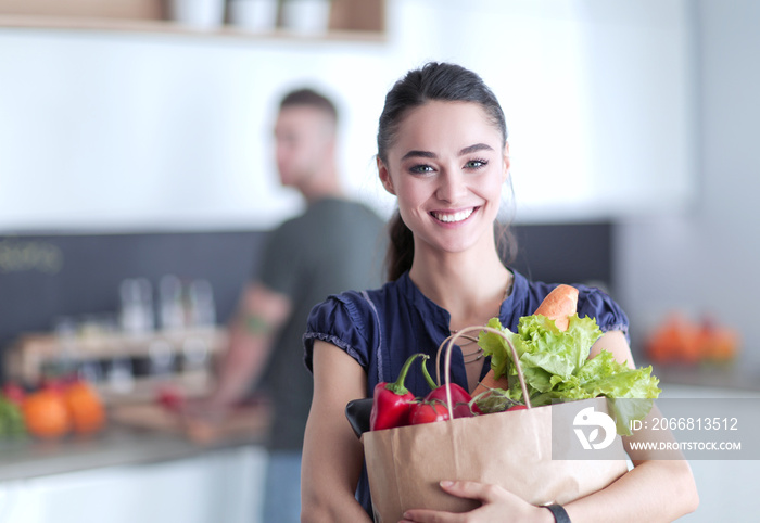 Young couple in the kitchen , woman with a bag of groceries shopping