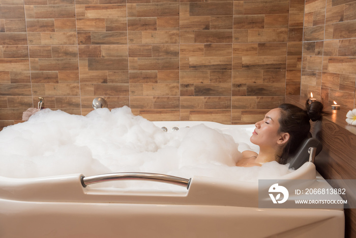 Bathing woman relaxing in bath smiling relaxing. Multicultural Asian / Caucasian young woman in bathtub.