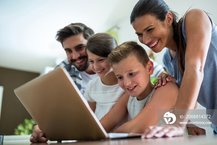 Happy family using laptop in the living room