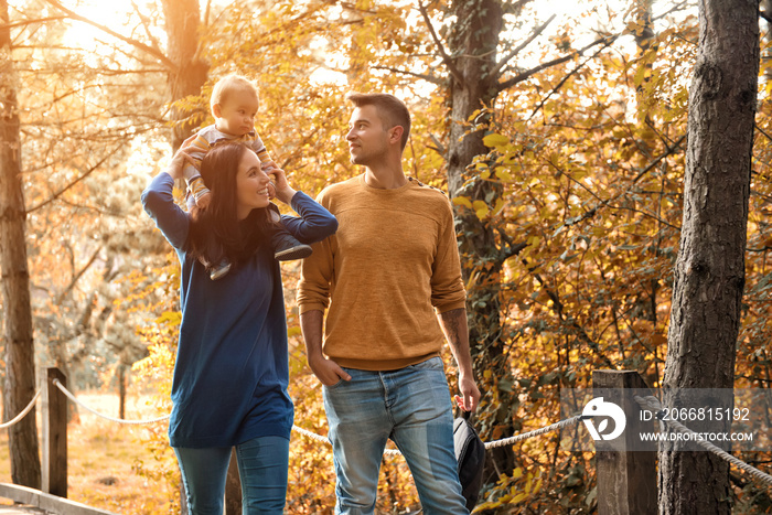 A young couple walks in the woods with a little boy