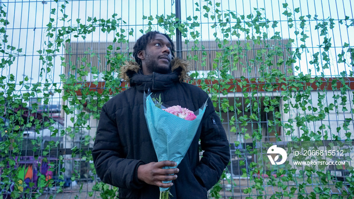 Young man holding bouquet in city