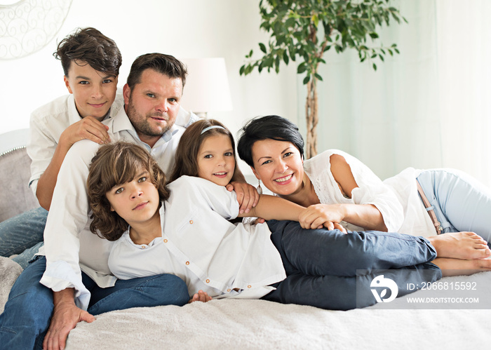 happy family with two children lying down and looking at camera - portrait