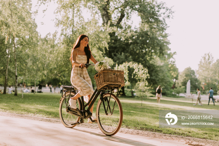 Young woman with electric bike and flowers in the basket