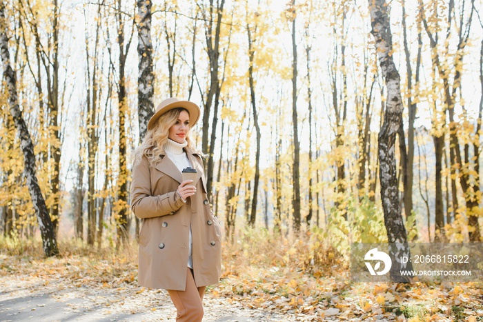 Happy smiling young woman in park on autumn day.