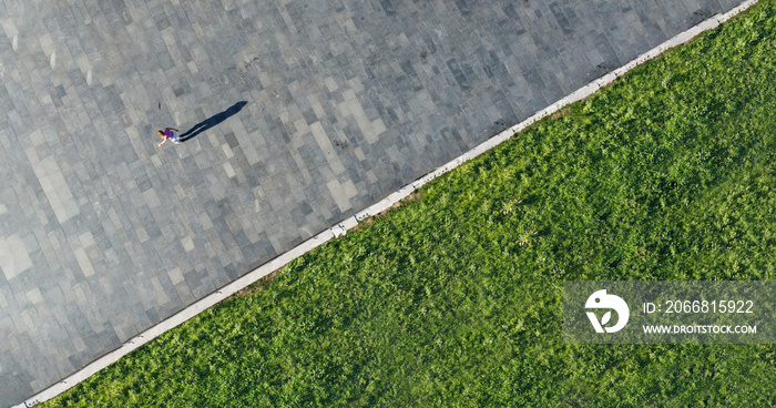 Drone shot of a young woman enjoying a beautiful sunny day on roller skates