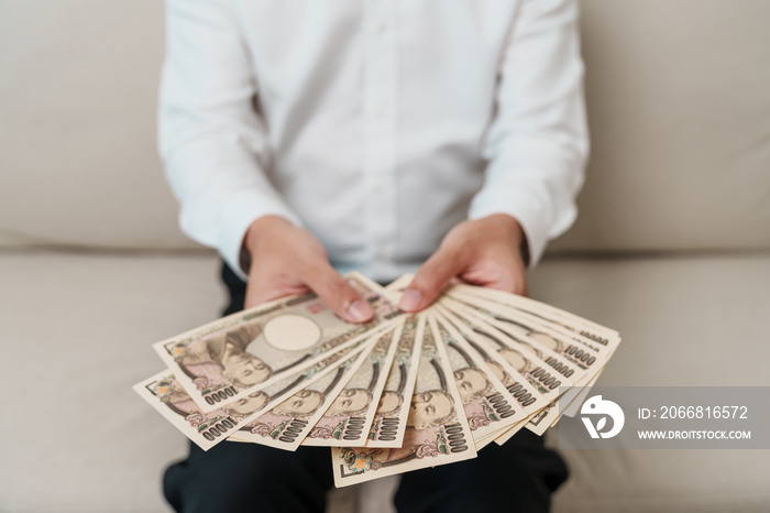 man hand holding Japanese Yen banknote stack. Thousand Yen money. Japan cash, Tax, Recession Economy, Inflation, Investment, finance and shopping payment concepts