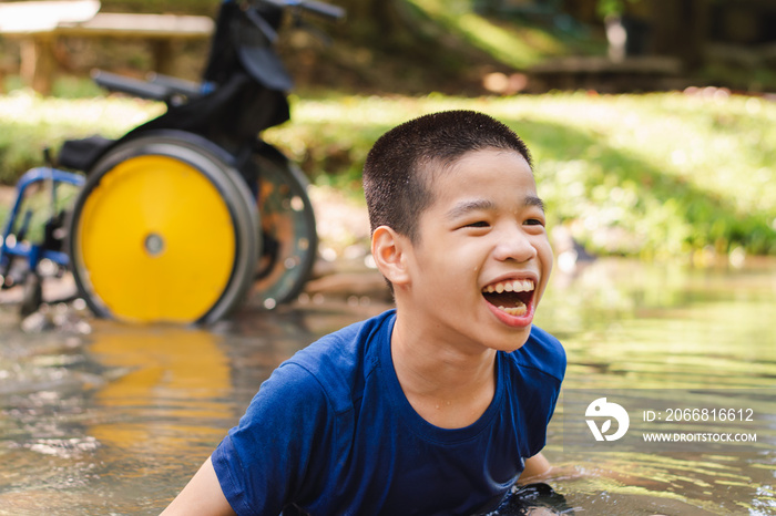 Disabled child on wheelchair is playing, learning and exercise in the outdoor city park like other people,Lifestyle of special child,Life in the education age of children,Happy disability kid concept.